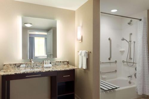 Homewood Suites by Hilton Frederick في فريدريك: حمام مع حوض وحوض استحمام ودش