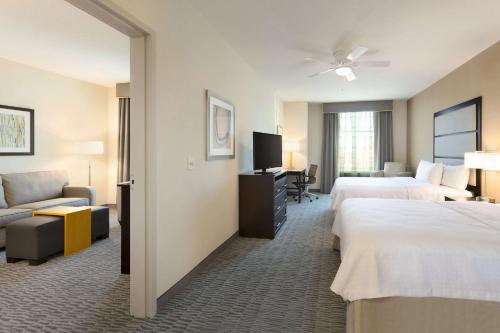 a hotel room with two beds and a couch at Homewood Suites by Hilton Frederick in Frederick