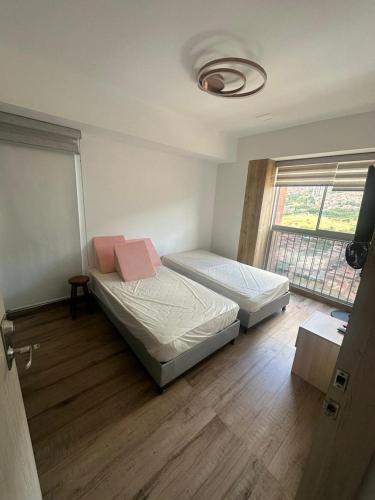 Duas camas num quarto com uma janela em Hermoso y lujoso apartamento en Bello em Bello