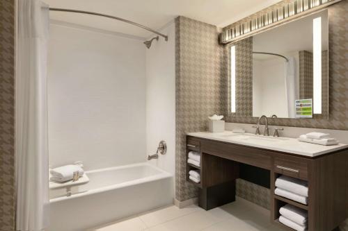 a bathroom with a tub and a sink at Home2 Suites By Hilton Chantilly Dulles Airport in Chantilly