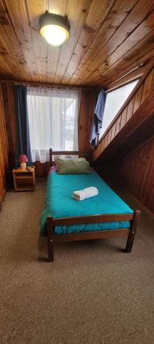 una camera con un letto in una cabina di legno di Hospedajes Roma a Valdivia