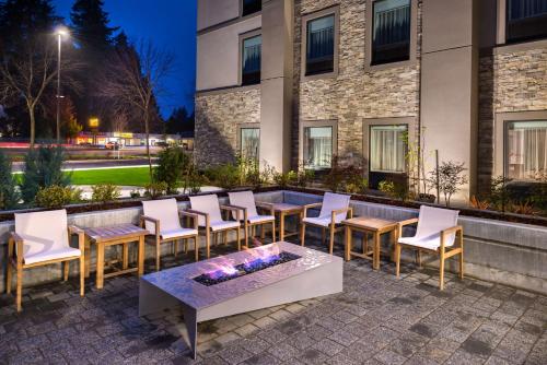 a patio with tables and chairs in front of a building at Hampton Inn & Suites Olympia Lacey, Wa in Olympia