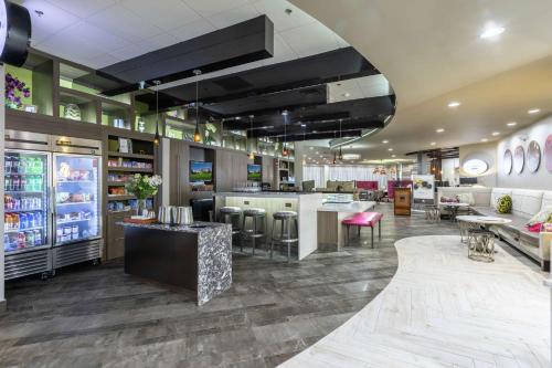 a restaurant with a bar with stools and tables at DoubleTree by Hilton Winston Salem - University, NC in Winston-Salem