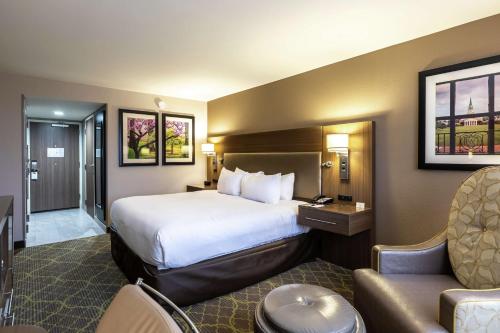 een hotelkamer met een groot bed en een stoel bij DoubleTree by Hilton Winston Salem - University, NC in Winston-Salem