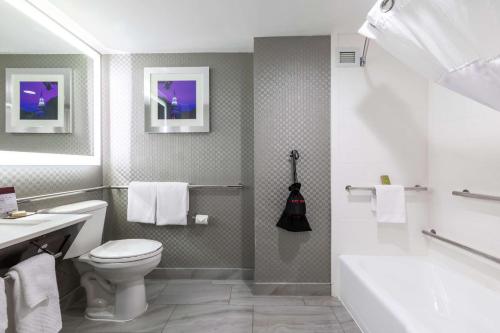 a bathroom with a toilet and a tub and a sink at DoubleTree by Hilton Winston Salem - University, NC in Winston-Salem