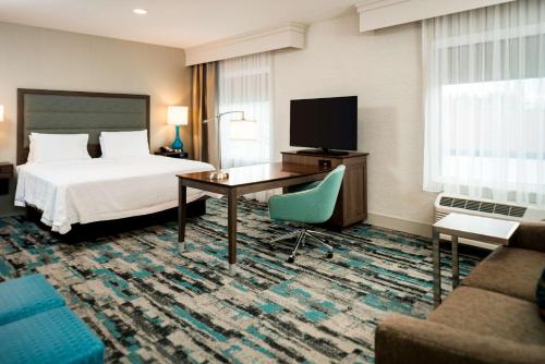 a hotel room with a bed and a desk and a tv at Hampton Inn & Suites Olympia Lacey, Wa in Olympia