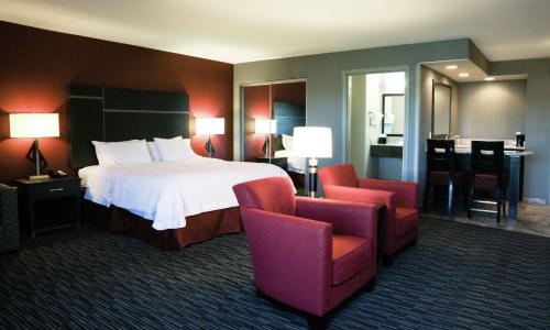 a hotel room with a bed and two chairs at Hampton Inn & Suites Temecula in Temecula