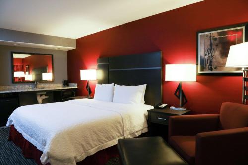 a hotel room with a large bed and a chair at Hampton Inn & Suites Temecula in Temecula