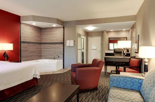 Hampton Inn & Suites Temecula في تيميكولا: غرفة فندق بسرير كنج وحمام