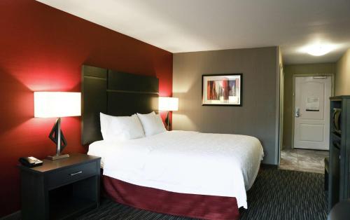 a hotel room with a white bed and red walls at Hampton Inn & Suites Temecula in Temecula