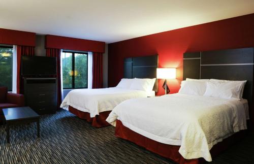 a hotel room with two beds and a red wall at Hampton Inn & Suites Temecula in Temecula