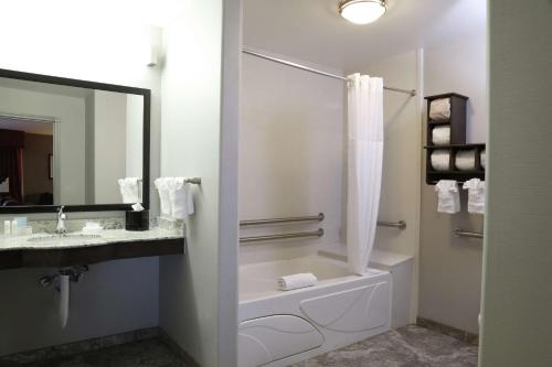 a bathroom with a tub and a sink and a toilet at Hampton Inn & Suites Temecula in Temecula