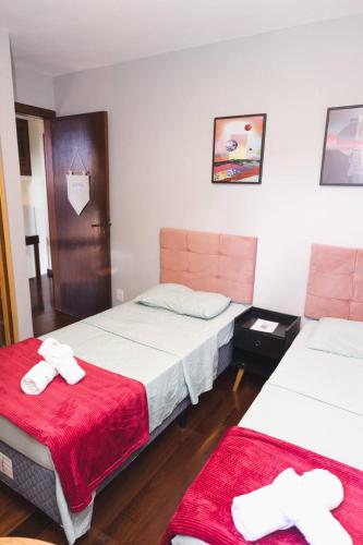 a room with two beds with red blankets at Hostel Jardim das Bruxas 410 in Florianópolis