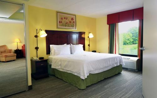 a hotel room with a bed and a window at Hampton Inn and Suites of Lamar in Mill Hall