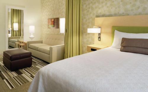 une chambre d'hôtel avec un lit et un canapé dans l'établissement Home2 Suites By Hilton La Crosse, à La Crosse