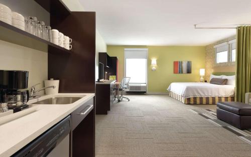 a hotel room with a bed and a kitchen at Home2 Suites By Hilton La Crosse in La Crosse