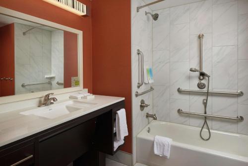 a bathroom with a tub and a sink and a shower at Home2 Suites By Hilton Muskogee in Muskogee