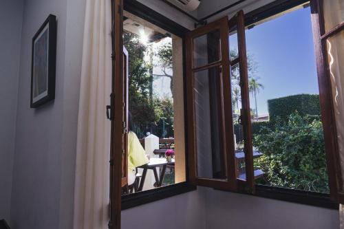 a window in a room with a view of a patio at Hostel Jardim das Bruxas 410 in Florianópolis