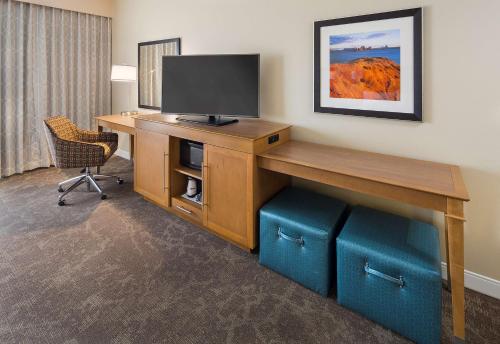 a room with a desk with a television and a chair at Hampton Inn & Suites Page - Lake Powell in Page