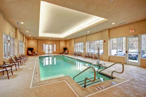 a swimming pool in a hotel room with tables and chairs at Homewood Suites - Doylestown in Warrington