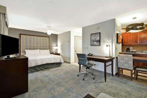 a hotel room with a bed and a desk with a computer at Homewood Suites by Hilton Palm Desert in Palm Desert