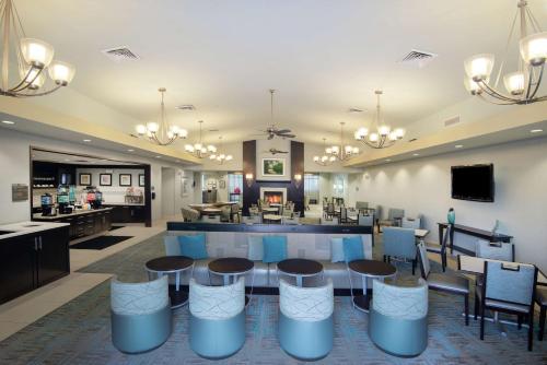 a lobby with a table and chairs and a bar at Homewood Suites Port Saint Lucie-Tradition in Port Saint Lucie