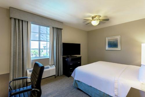 a hotel room with a bed and a television at Homewood Suites Port Saint Lucie-Tradition in Port Saint Lucie