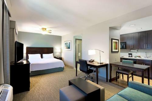 a hotel room with a bed and a desk at Homewood Suites Port Saint Lucie-Tradition in Port Saint Lucie