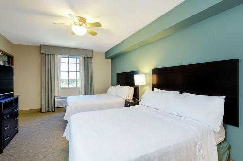 a hotel room with two beds and a ceiling fan at Homewood Suites Port Saint Lucie-Tradition in Port Saint Lucie
