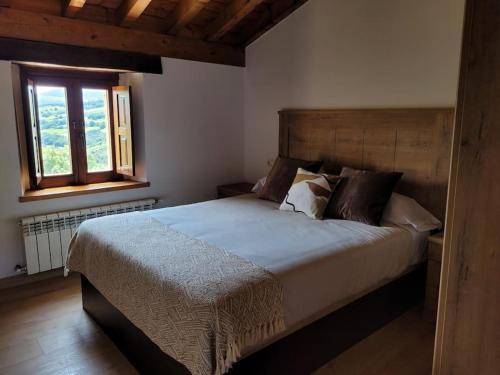 Un dormitorio con una cama grande y una ventana en Cabaña Pasiega Montes del Pas, 