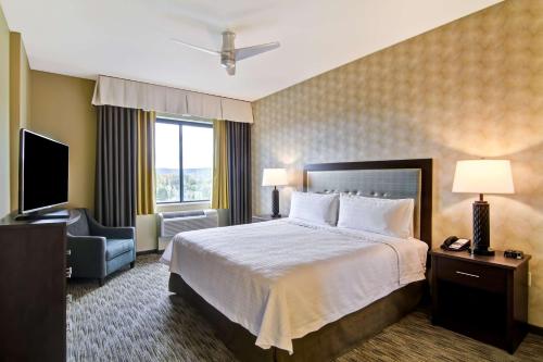 a hotel room with a bed and a television at Homewood Suites by Hilton Seattle-Issaquah in Issaquah