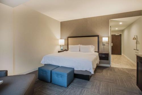 a hotel room with a bed and a mirror at Hampton Inn Rochester Penfield, Ny in Penfield