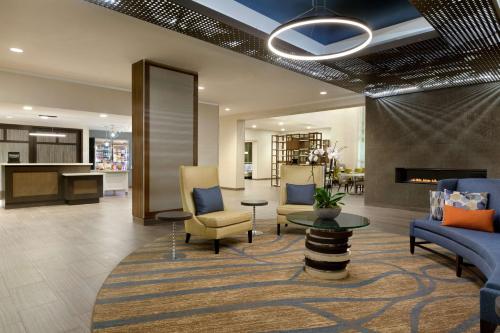 a lobby with a waiting area with chairs and a table at Homewood Suites By Hilton Irvine John Wayne Airport in Irvine
