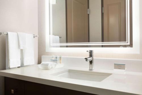 y baño con lavabo blanco y espejo. en Homewood Suites By Hilton Irvine John Wayne Airport, en Irvine