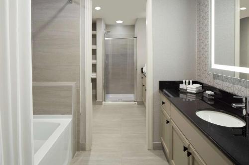y baño con bañera, lavamanos y ducha. en Homewood Suites by Hilton Mont-Tremblant Resort en Mont-Tremblant