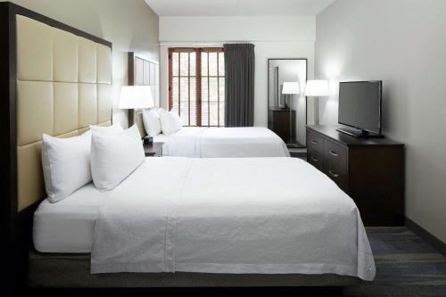 a hotel room with two beds and a flat screen tv at Homewood Suites by Hilton Mont-Tremblant Resort in Mont-Tremblant
