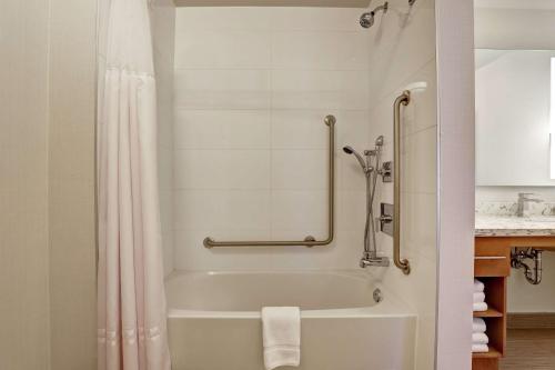 a bathroom with a bath tub with a shower curtain at Homewood Suites By Hilton Ottawa Kanata in Ottawa