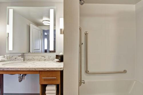 uma casa de banho com um chuveiro e um lavatório. em Homewood Suites By Hilton Ottawa Kanata em Ottawa
