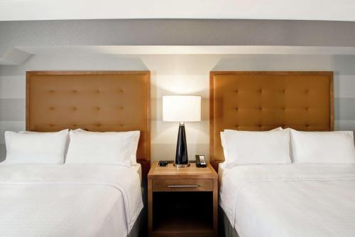 a hotel room with two beds and a lamp on a night stand at Homewood Suites By Hilton Ottawa Kanata in Ottawa