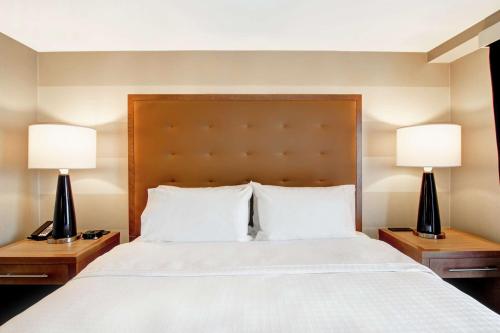 a bedroom with a large bed with two lamps on tables at Homewood Suites By Hilton Ottawa Kanata in Ottawa
