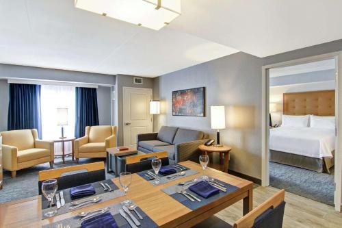 - une chambre d'hôtel avec un lit king-size et un salon dans l'établissement Homewood Suites By Hilton Ottawa Kanata, à Ottawa