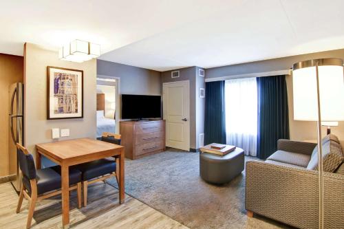 a living room with a table and a couch and a room at Homewood Suites By Hilton Ottawa Kanata in Ottawa