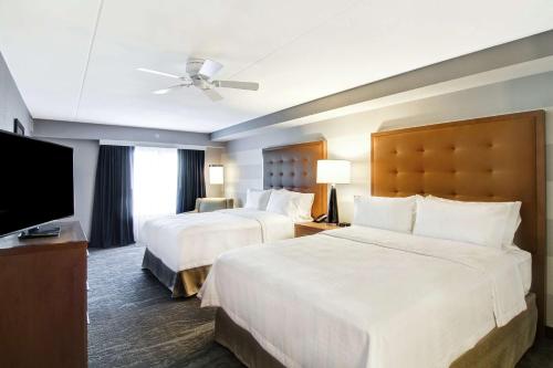 a hotel room with two beds and a flat screen tv at Homewood Suites By Hilton Ottawa Kanata in Ottawa