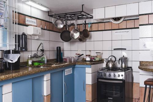 a kitchen with a stove and a counter top at Hostel Jardim das Bruxas 410 in Florianópolis