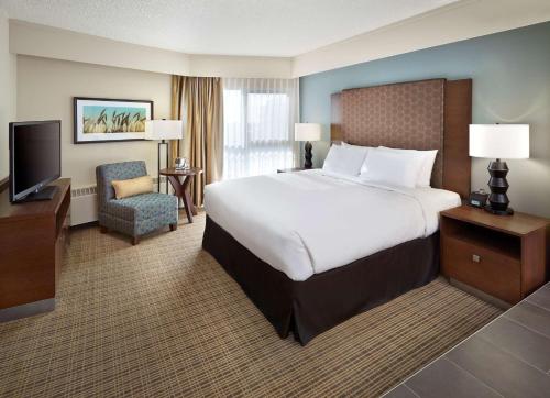 DoubleTree by Hilton Hotel & Conference Centre Regina في ريجينا: غرفه فندقيه سرير كبير وتلفزيون