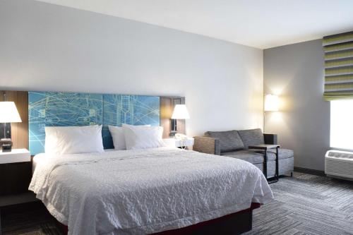 a hotel room with a bed and a chair at Hampton Inn Hamburg in Hamburg