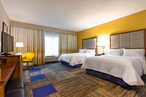 um quarto de hotel com duas camas e uma televisão de ecrã plano em Hampton Inn Lockport - Buffalo, NY em Lockport