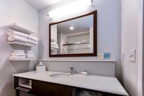 a bathroom with a sink and a mirror and towels at Hampton Inn Lockport - Buffalo, NY in Lockport