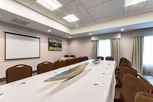 a conference room with a table and chairs and a screen at Hampton Inn Lockport - Buffalo, NY in Lockport