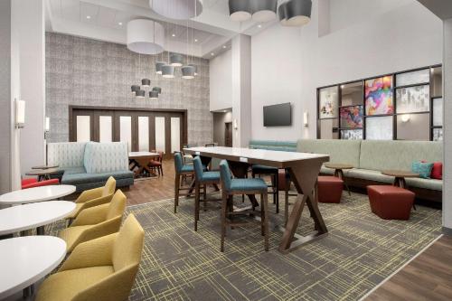 uma sala de espera com uma mesa e cadeiras em Hampton Inn & Suites Lexington em Lexington